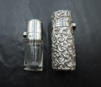 A Victorian silver scent phial having extensive embossed scroll decoration with glass lining and