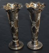 A pair of Edwardian silver bud or spill vases, having moulded and flared rims over the tapering