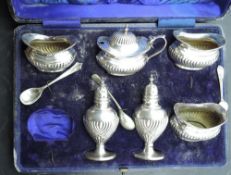 A cased silver condiment set having gadrooned decoration, Birmingham 1912, Joseph Gloster Ltd,