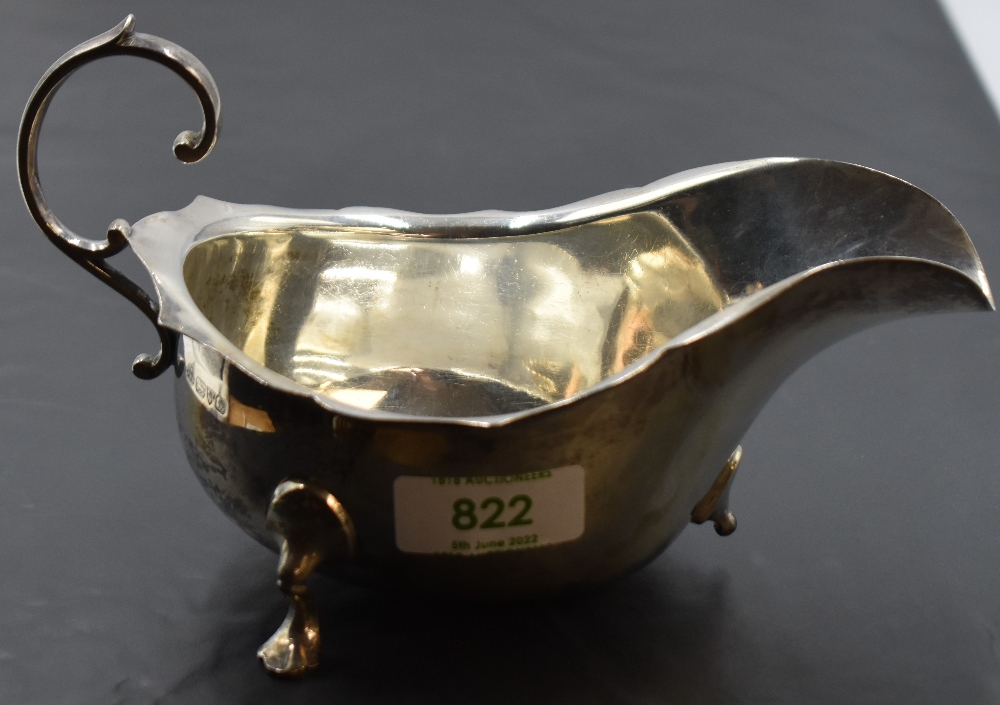 An early 20th century silver gravy boat, of generous proportions with scrolled handle and trefoil