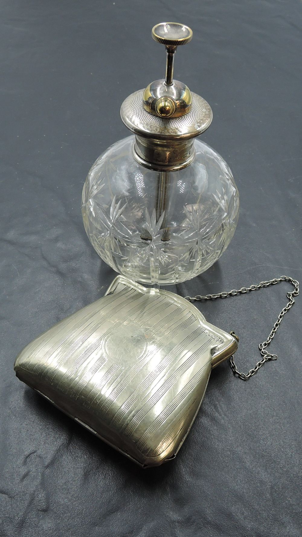 A silver mounted cut glass perfume atomizer, with brass pump and nozzle over the engine turned