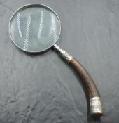 A white metal mounted antler handled magnifying glass, the curved antler handle with embossed