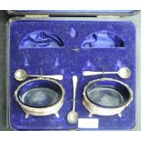 A pair of Edwardian cased silver salts, of moulded oval form with fluted cabriole type legs, marks