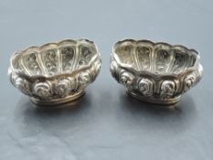 A pair of Edwardian Silver salts, of oval form embossed with scrolling panels, marks for