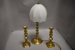 An Edwardian twist stem brass lamp having milk glass shade along with two candle sticks