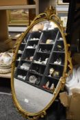 A mid century mirror having scroll work brass effect frame