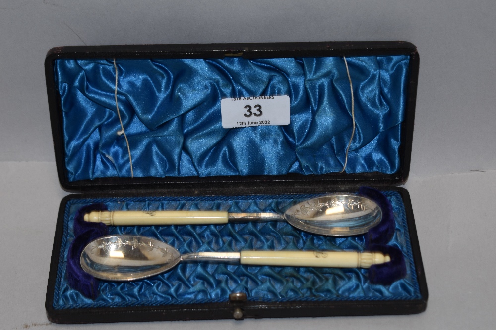 A pair of late Victorian case white metal and bone handle spoon set, handle engraved with initial J