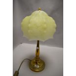 An art deco era table lamp having brass base with mottled yellow and cream glass shade