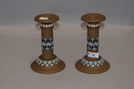 A pair of silicon ware candlesticks circa 1880, having blue and white detailing to beige ground,