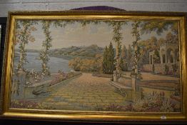 A framed machine woven tapestry showing classical scene with mountains and sea.