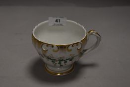 An antique tea cup by Schumann marked SPM to base having gilt and ivy decoration