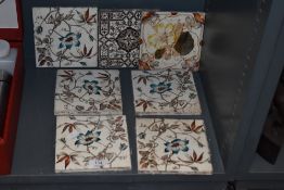 A set of five plus two Victorian ceramic tiles having transfer printed and hand tinted designs