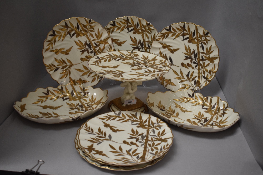 A selection of antique porcelain dinner wares having silver and gilt bamboo and bird decoration