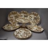 A selection of antique porcelain dinner wares having silver and gilt bamboo and bird decoration