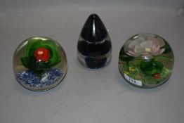 Three modern paper weights one by Wedgwood and two having floral lamp work designs