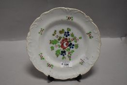 A 19th century hand decorated tin glaze plate, with foliate moulding to the rim.