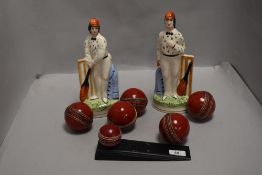 A pair of Staffordshire flat back figures of cricketers and a selection of cricket balls