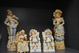 Five porcelain bisque figures including a larger mantle pair and three seated figures