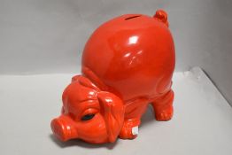 A large red ceramic piggy bank