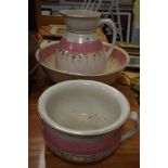 A wash jug and bowl set having white ground with pink and gilt decoration