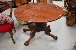 A Victorian style mahogany table having extensive carving to legs with four lions paws on castors.