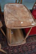 An Ercol light elm drinks trolley, of traditional design, bearing Ercol label, damage to central