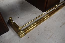 An antique brass fire guard or hearth surround.