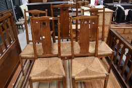 A set of five (four plus one) Arts and Crafts (probably Arthur Simpson) golden oak dining chairs