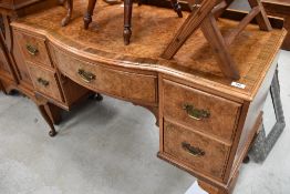 An early 20th century burr walnut veneered dressing table having two drawers to either side and