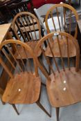 A set of four Ercol stick back elm seated chairs, lacking label but bearing BS stamp.