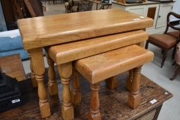 A nest of three modern light oak tables, of traditional design