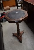 A William IV walnut occasional table having octagonal top with leather inset and inlay, carved