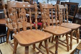 A set of five modern pine kitchen chairs, with pierced central splat and flanking spindles.