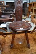 An arts and crafts spinners stool, having floral carving to seat and back rest, possibly Welsh.