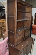 A 20th century oak book case cupboard with carved frontage