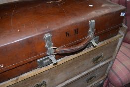 A vintage stitched leather effect suitcase, with label reading 'Revelation'