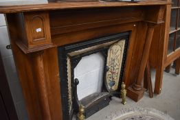 A stained frame fire surround and reproduction Art Nouveau style cast iron and tiled fireplace