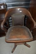 A 1930's mahogany swivel office chair, with padded seat and back over the sprung adjustable