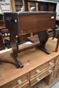 An early 20th century mahogany sewing table, with trestle style base