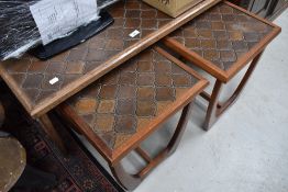 A nest of three tile topped teak tables, most likely Scandinavian