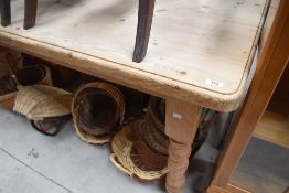 A large modern pine farmhouse kitchen table, of rounded rectangular form with turned supports.