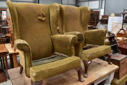 A pair of vintage Parker Knoll wing back armchairs, to reupholster, lacking cushions.