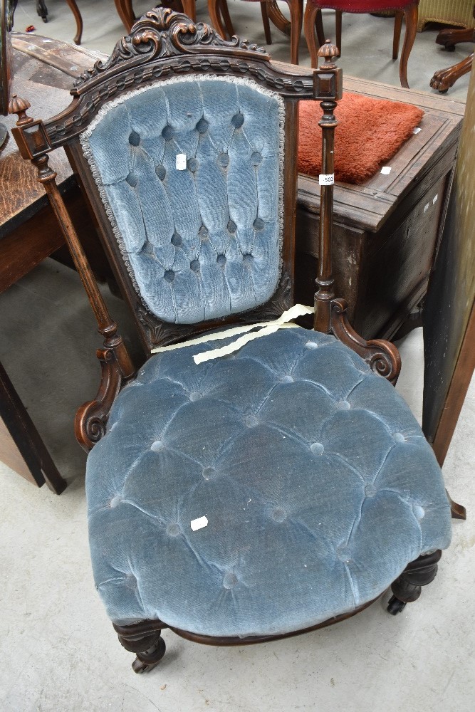 A mid Victorian nursing chair having ornate carved back with pillar supports
