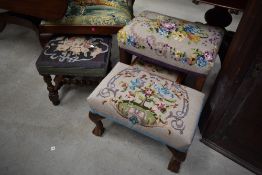 A collection of stools having needle point cushions.