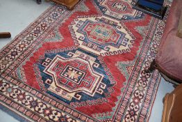 A North West Persian rug, with three large central guls enclosed by multiple borders 210cm x140cm