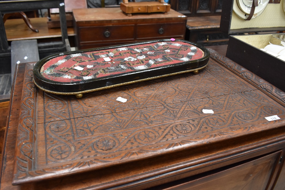 A 19th century beadwork stand, of rounded oblong form, sold together with an oak Arts and Crafts
