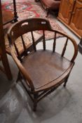 An early 20th century oak spindled tub armchair with applied solid ply seat.