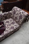 A modern chaise longue, upholstered in purple foliate patterned material.