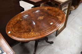 A late Victorian inlaid centre table, of oval form with string and foliate inlaid decoration over
