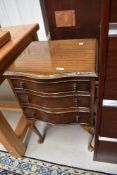 An early 20th Century mahogany serpentine front three drawer bedside or similar chest on cabriole